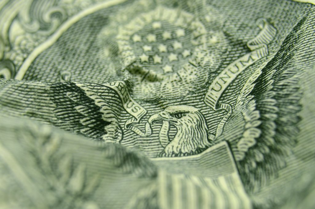 Shallow depth of field close, up of the eagle, from the US Coat of Arms, on a wrinkled, American, one dollar bill.