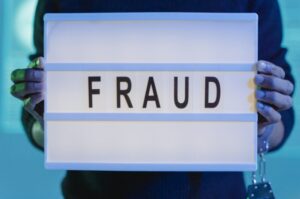 Man holding a "fraud" sign.